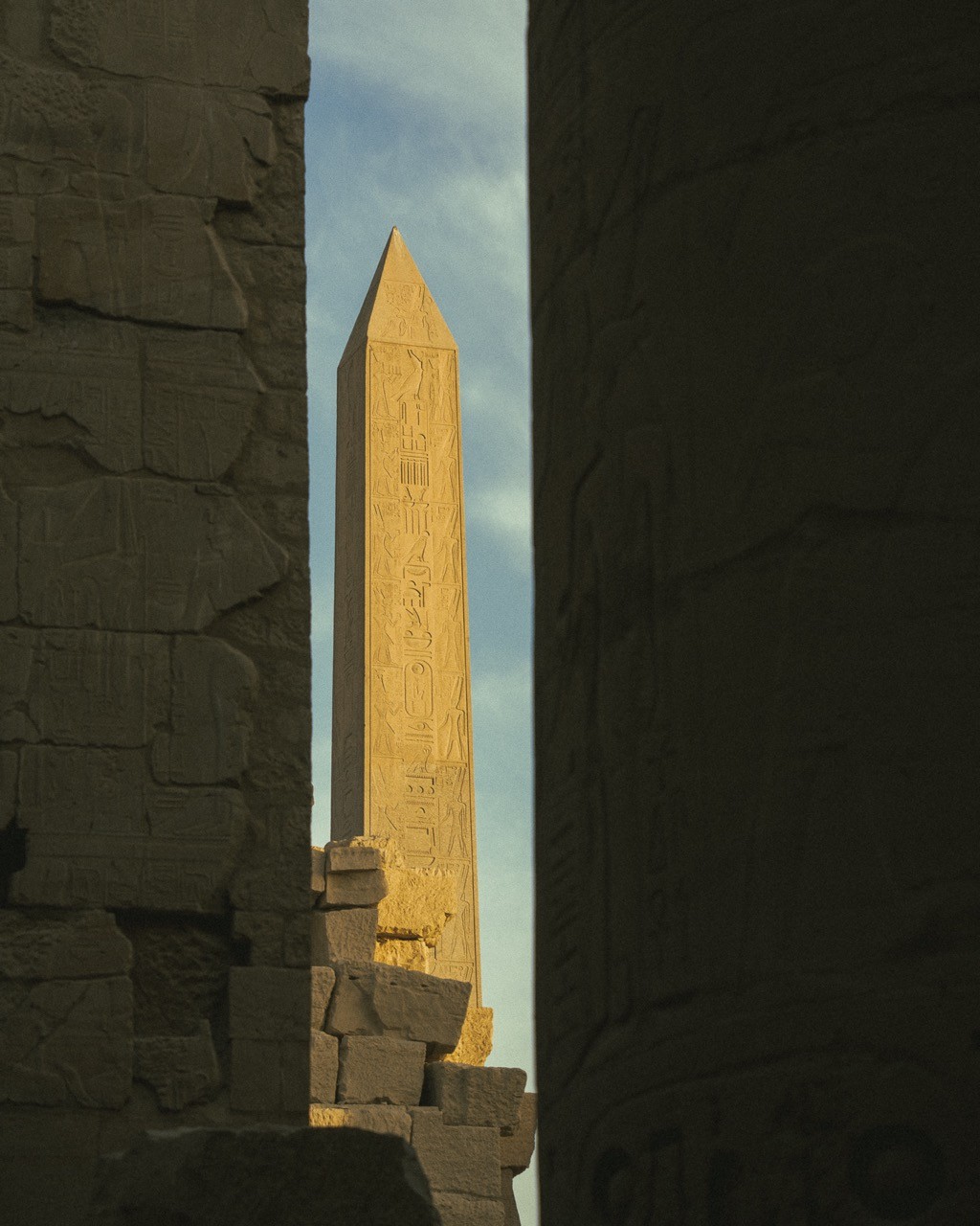 An obelisk peeking out from behind the great columns at Karnak.