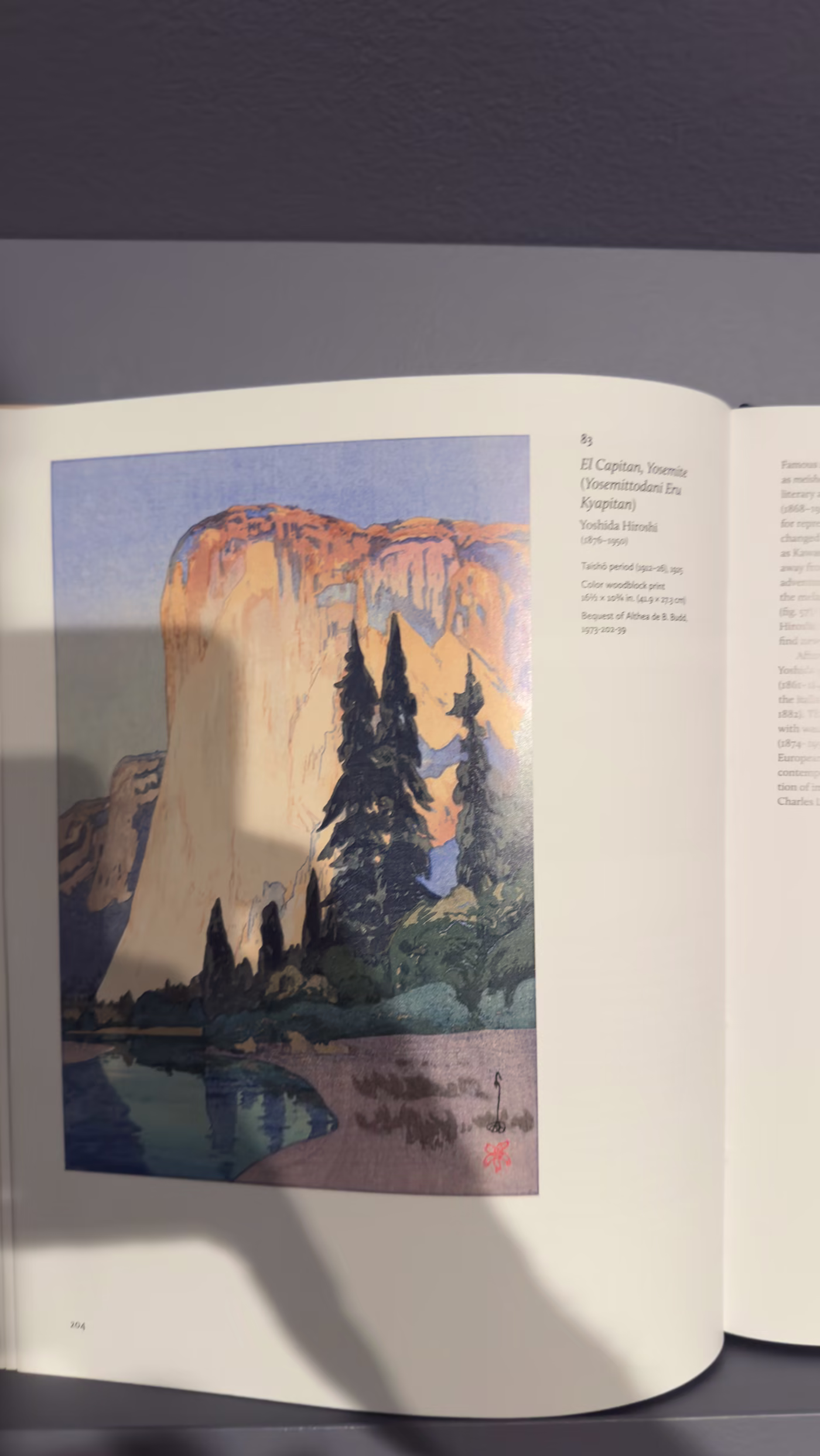 A photo of a catalog page at the Philadelphia Museum of Art showing Yoshida Hiroshi's woodblock print El Capitan, Yosemite (1925): a sunlit granite monolith above a still reflecting pool and dark pines.