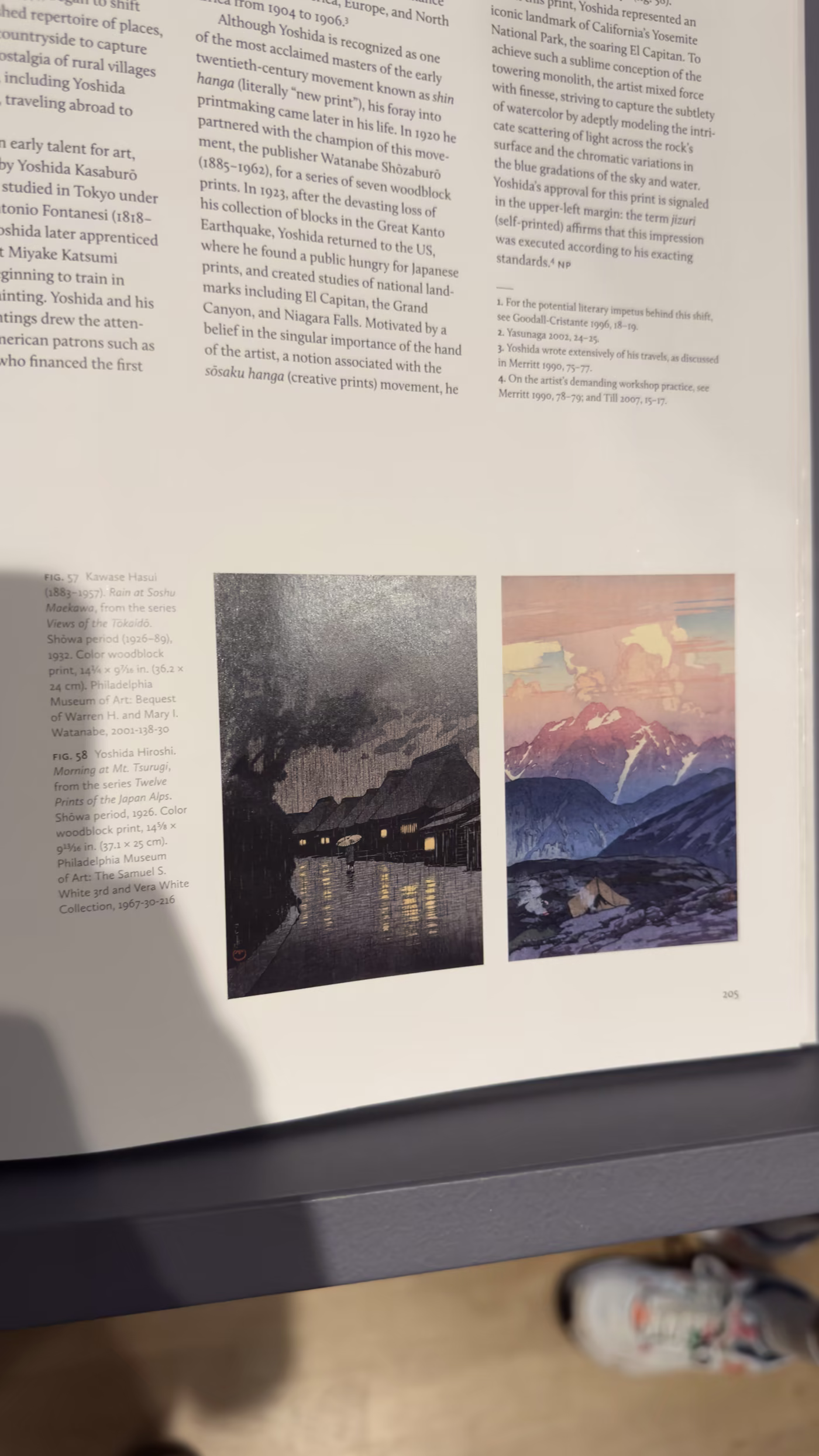 A photo of a catalog spread showing two woodblock prints: Kawase Hasui's Rain at Soshu Maekawa, a rainy village at night, and Yoshida's Morning at Mt. Tsurugi, a pink dawn-lit alpine peak.